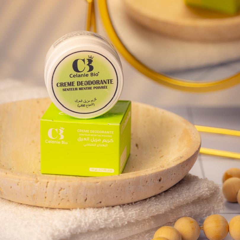 Pot de déodorant naturel posé sur une serviette blanche avec des ingrédients bio comme le beurre de karité, l’huile d’amande douce et l’oxyde de zinc, évoquant une sensation de fraîcheur et de protection naturelle.