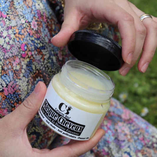 Pot de masque capillaire naturel pour femmes enceintes et enfants, entouré d’ingrédients naturels comme l’huile de ricin, la noix de coco, le beurre de karité et la figue de barbarie, posé sur une surface douce et élégante.