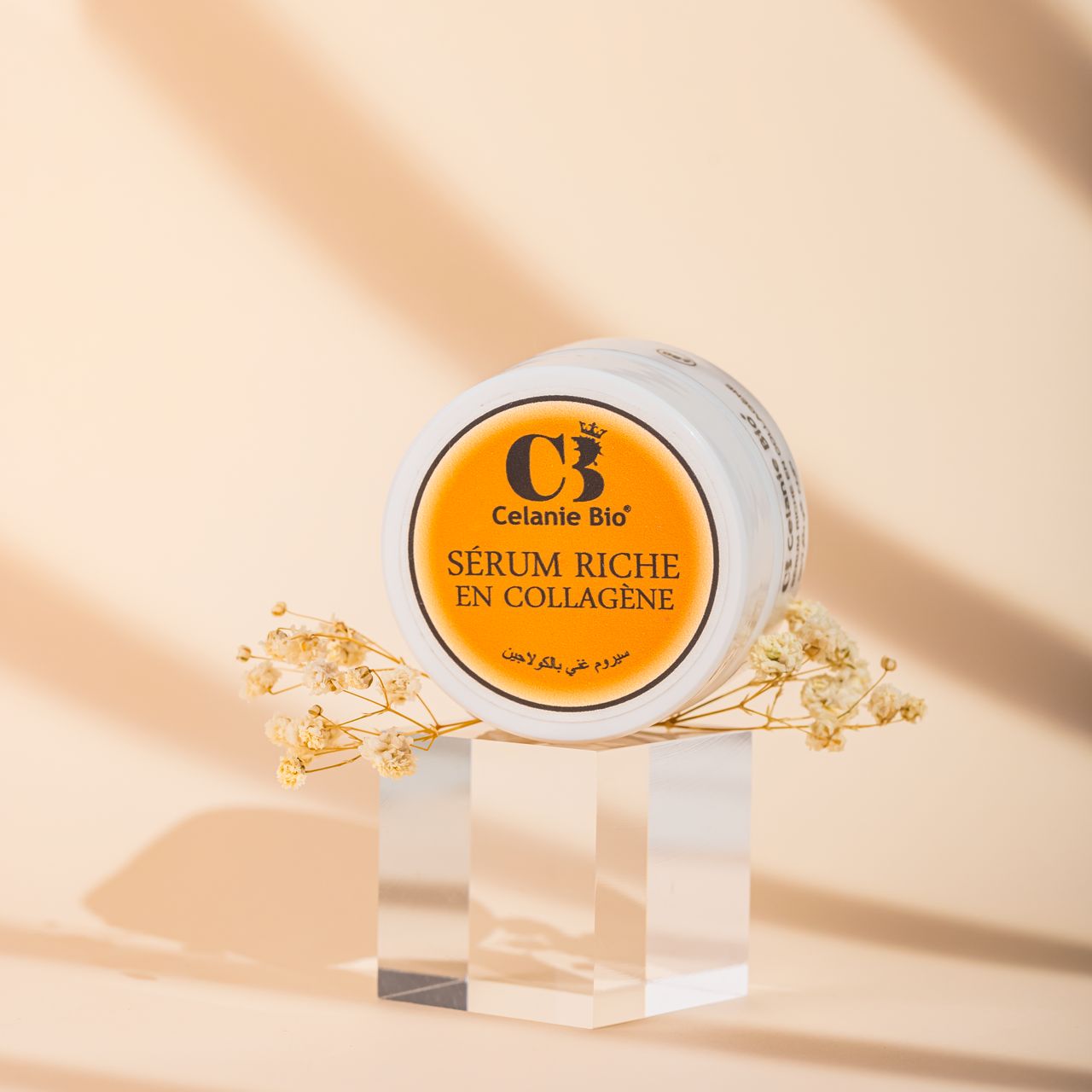 Flacon de sérum au collagène posé sur une surface élégante, accompagné d’ingrédients naturels comme l’aloe vera, la figue de barbarie et l’huile d’argan, avec une texture fluide lumineuse en arrière-plan.